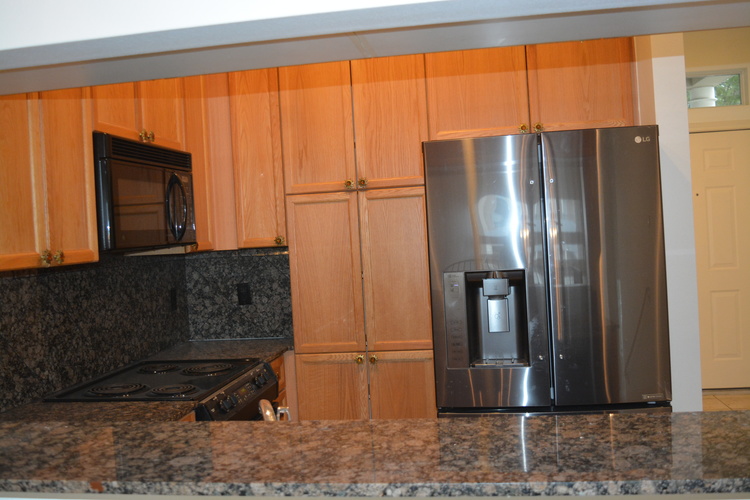 A kitchen with a stove, microwave, and refrigerator.
