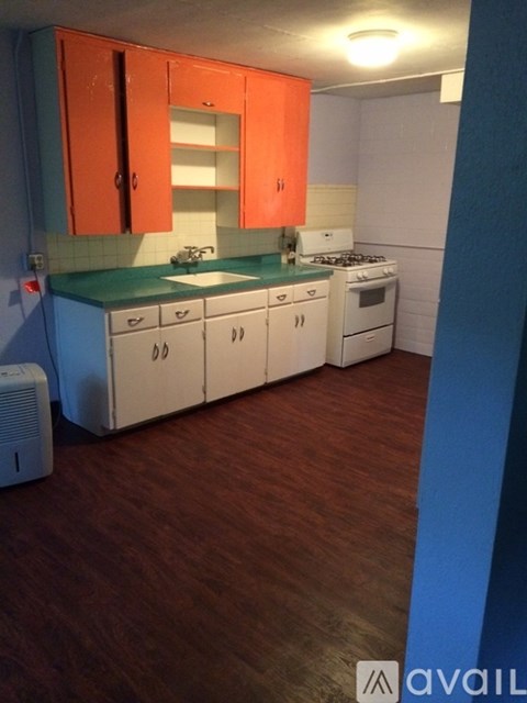 A kitchen with orange cabinets and a white stove.