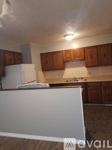 A kitchen with wooden cabinets and a white refrigerator.