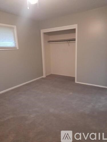 A room with a white door and a window with blinds.