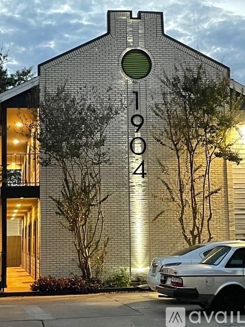 A car is parked in front of a building with the number 1904 on it.