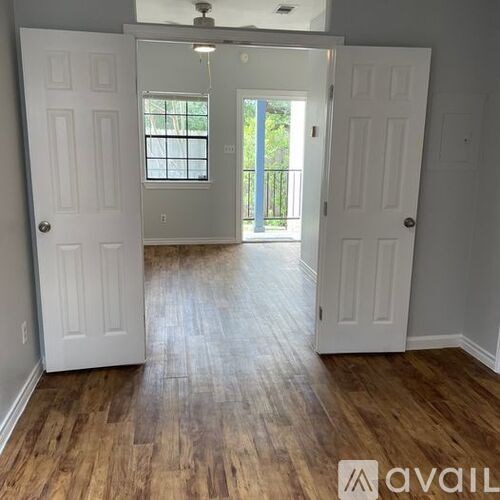 A room with white doors and wooden floors.