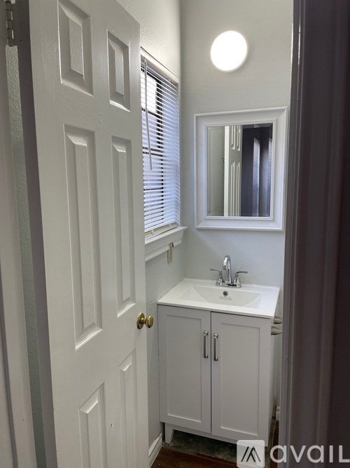 A white bathroom with a sink and mirror.