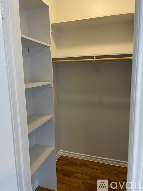 A white closet with shelves and a hanger bar.