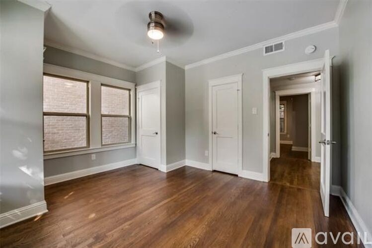 A room with wooden floors and a window with blinds.
