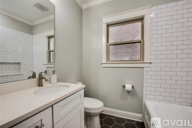 A bathroom with a toilet, sink, and a window.