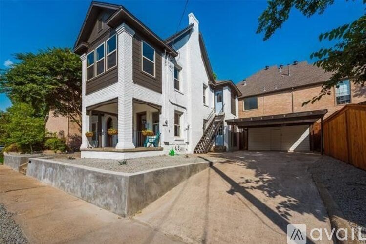 A modern house with a large front yard and a driveway.