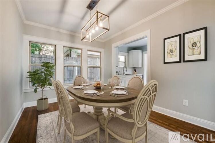 A dining room with a table set for four and a plant in a planter.