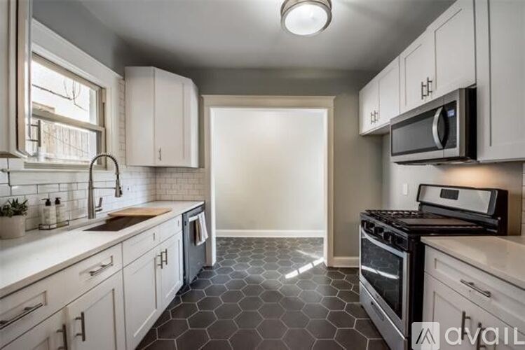 A kitchen with white cabinets and a black stove top oven.