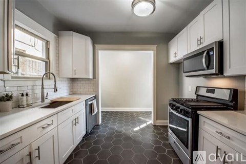 A kitchen with white cabinets and a black stove top oven.