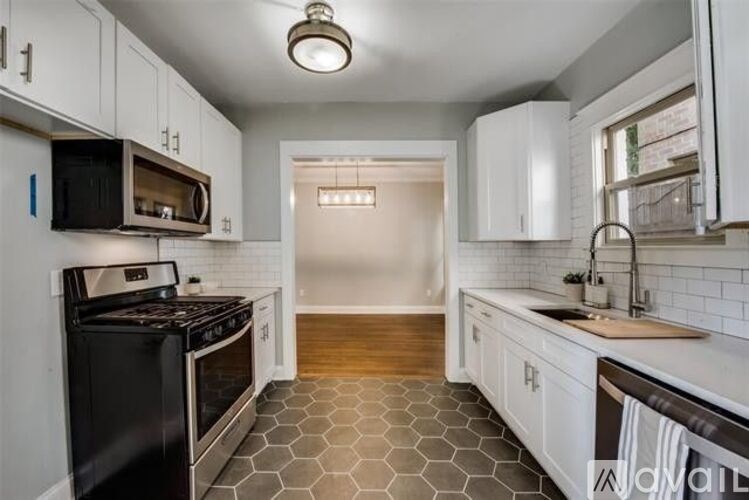 A kitchen with black appliances and white cabinets.