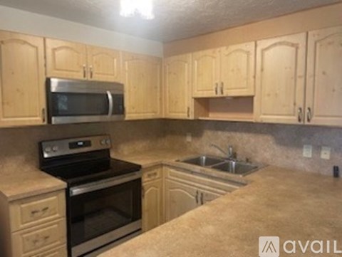 A kitchen with wooden cabinets and a granite countertop.