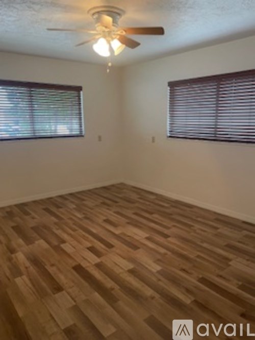 A room with wooden flooring and a ceiling fan.