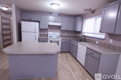 A kitchen with a white refrigerator and cabinets.