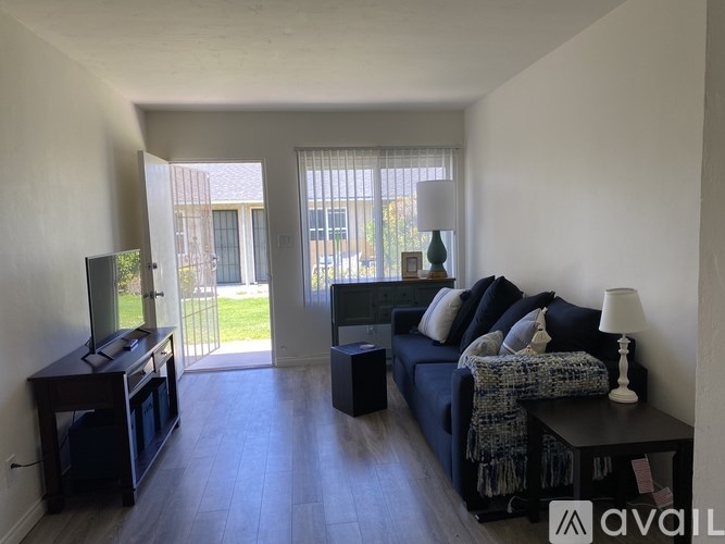 A living room with a black couch and a television.