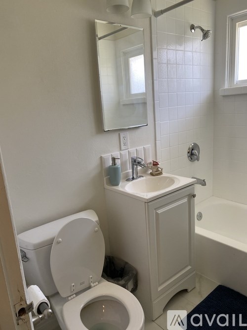 A white toilet with a sink and mirror in a bathroom.