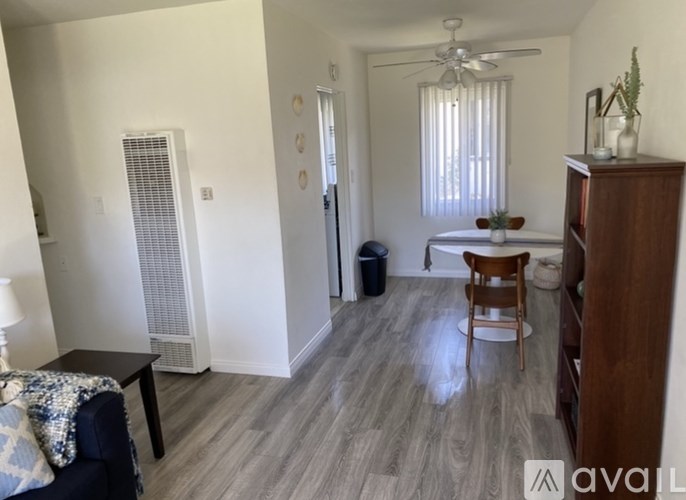 A living room with a blue couch and a wooden chair.