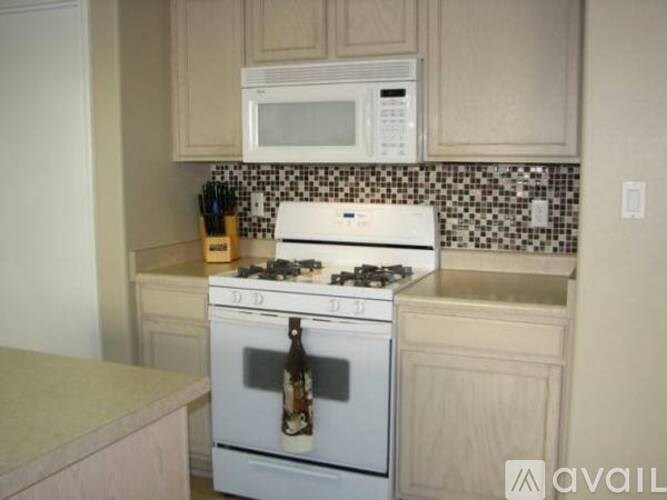 A kitchen with a white stove top oven and a microwave above it.