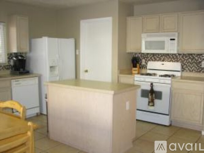 A kitchen with white appliances and a wooden table.