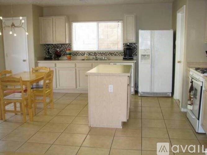 A kitchen with a table and chairs.