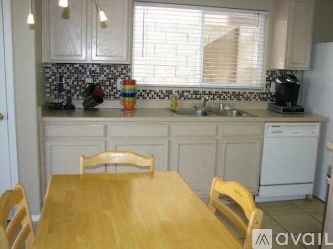 A kitchen with a wooden table and chairs.