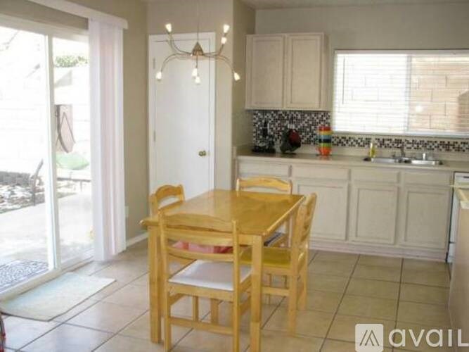 A kitchen with a table and chairs in front of a window.