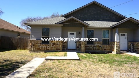A house with a white fence and a brown roof is for sale.