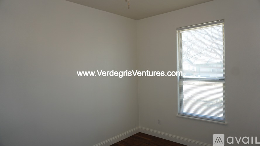A room with a window and a website address on the wall.