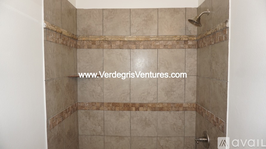A shower area with tiles and a shower head.