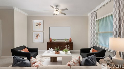 A living room with a ceiling fan, two chairs, a couch, a coffee table, and a painting on the wall.