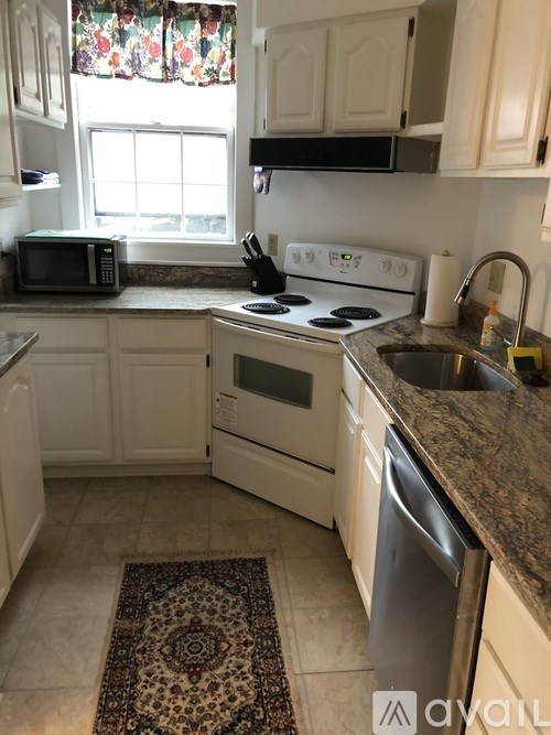 A kitchen with a stove top oven, microwave, and dishwasher.