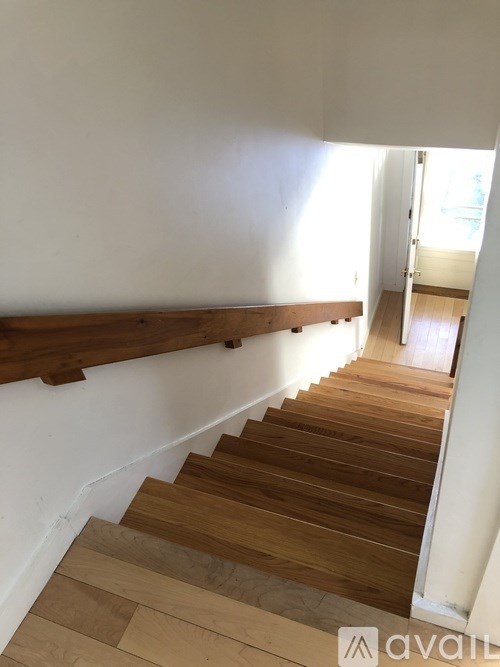 A wooden staircase with a white wall on the side.