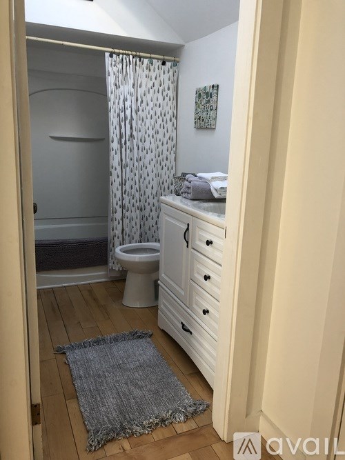 A bathroom with a toilet, sink, and shower.