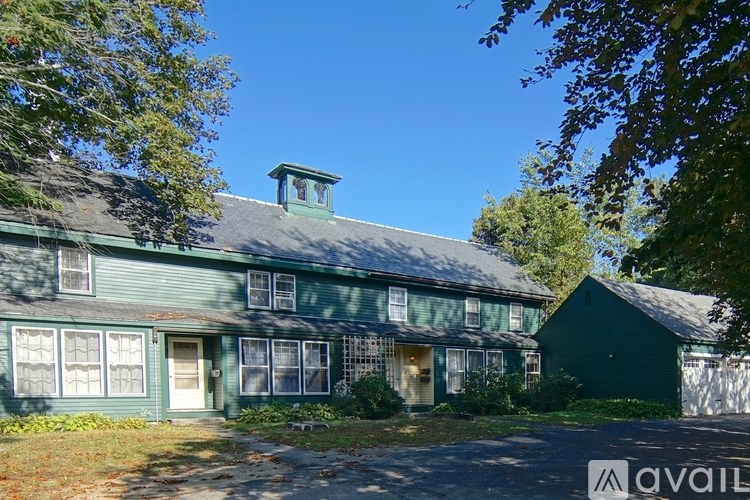 A green house with a white door and windows.