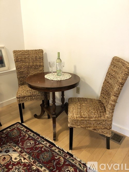 A table with two chairs and a glass of wine on it.