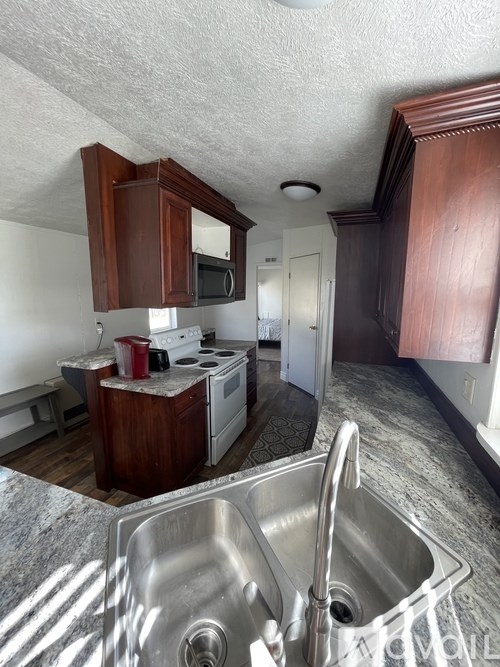 A kitchen with a stove, oven, and sink.
