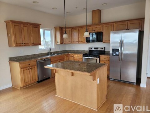 A kitchen with wooden cabinets and granite countertops.