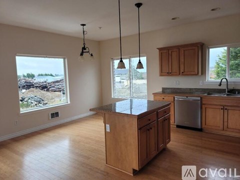 A kitchen with wooden cabinets and a large island in the middle.