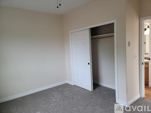 A room with a white door and carpeted floor.