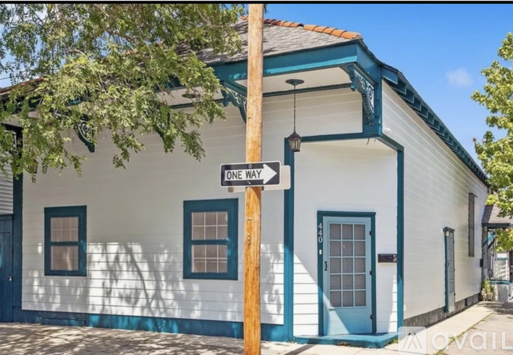 A white house with a blue door and a one way sign.