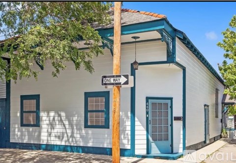 A white house with a blue door and a one way sign.