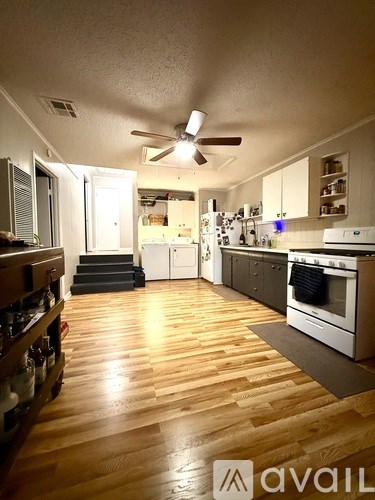 A kitchen with wooden floors and white appliances.