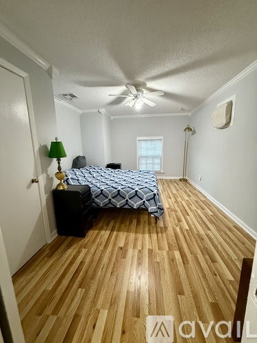 A bedroom with a bed, dresser, and ceiling fan.