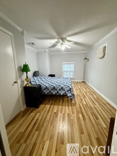 A bedroom with a bed, dresser, and ceiling fan.
