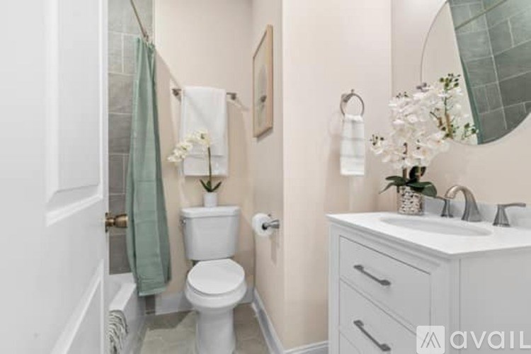 A bathroom with a toilet, sink, and mirror.