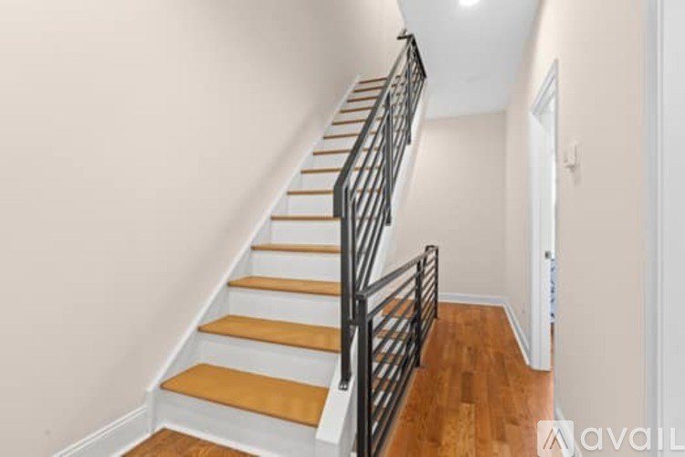 A staircase with wooden steps and a black metal railing.