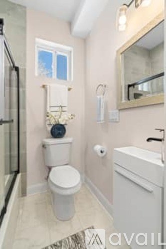 A bathroom with a toilet, sink, and mirror.