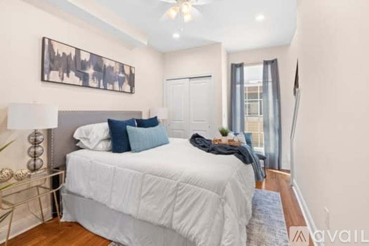 A bedroom with a large bed and a painting on the wall.