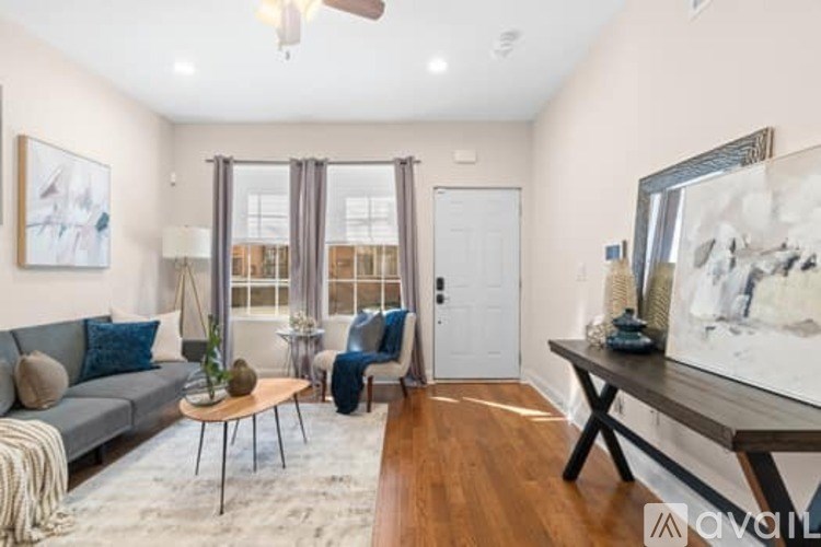 A living room with a grey couch, a coffee table, and a painting on the wall.