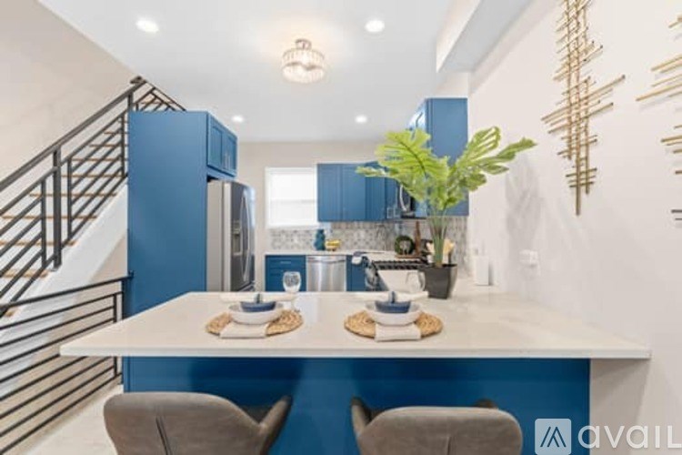 A modern kitchen with blue cabinets and a white island.